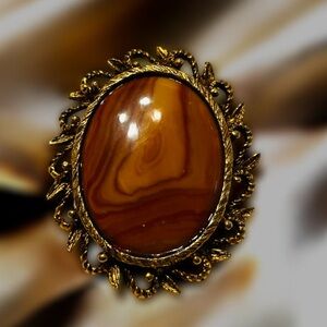 Vintage brooch oval polished stone, likely a agate or jasper intricate filigree